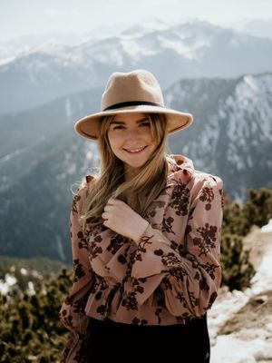 Frau auf Berg lacht in die Kamera
