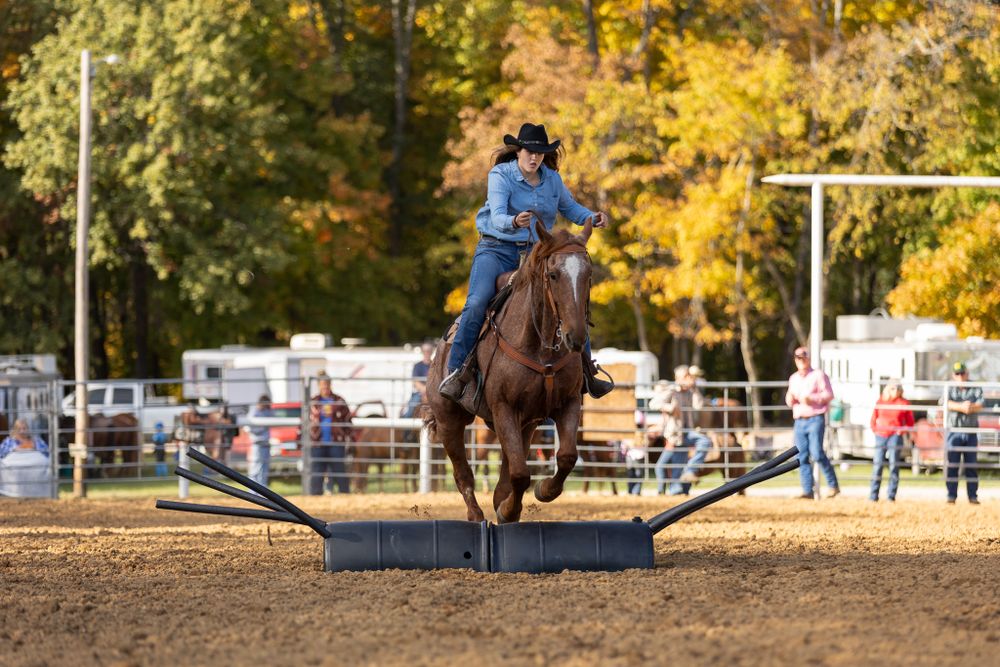 A young cowgirl jumps her horse over an obstacle outside of Olney, Illinois during the White Squirrel Saddle Club fun show.