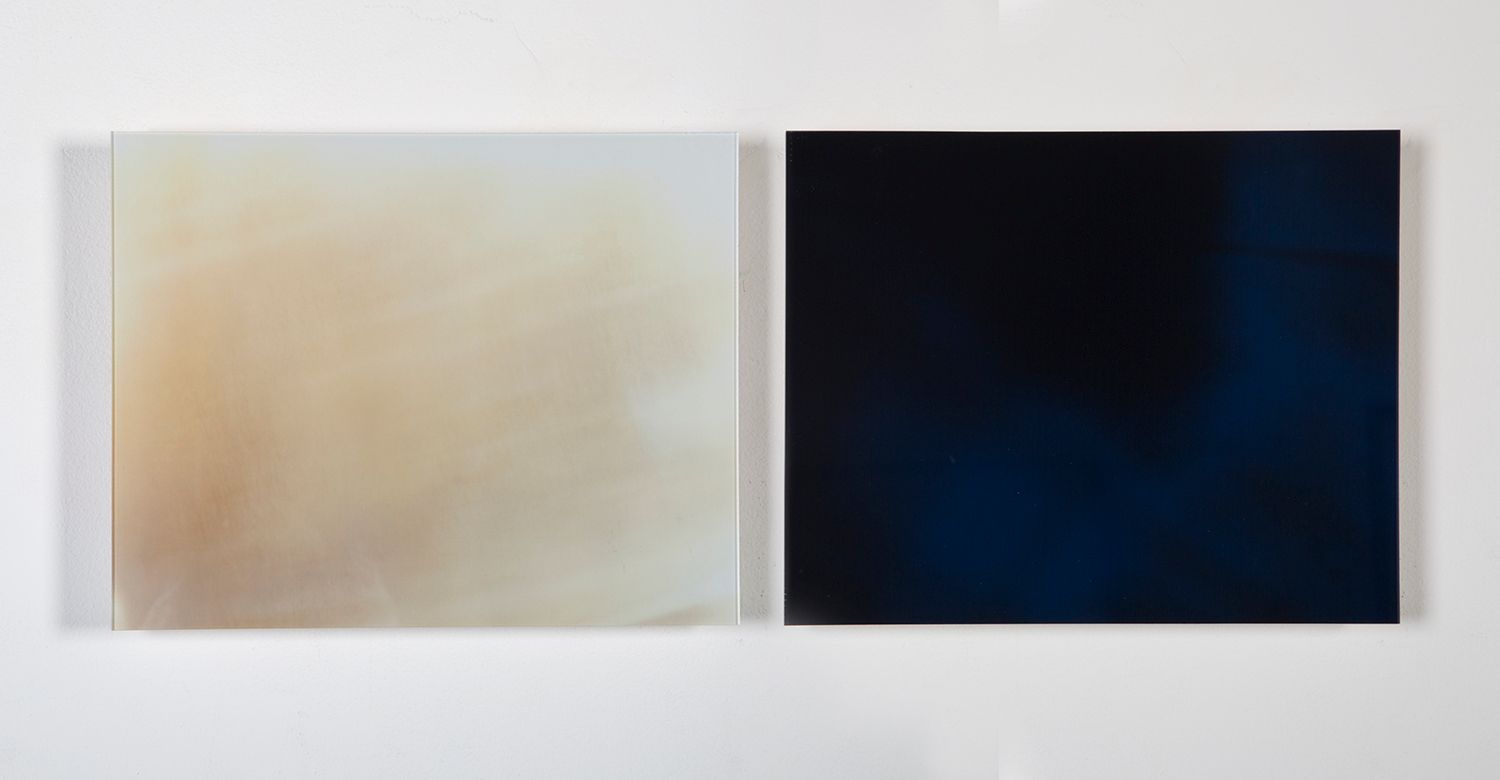 Minimalist gallery wall displaying abstract artworks in neutral tones.
