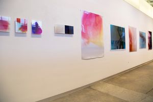 Art gallery wall displaying a series of colorful abstract prints in white space.