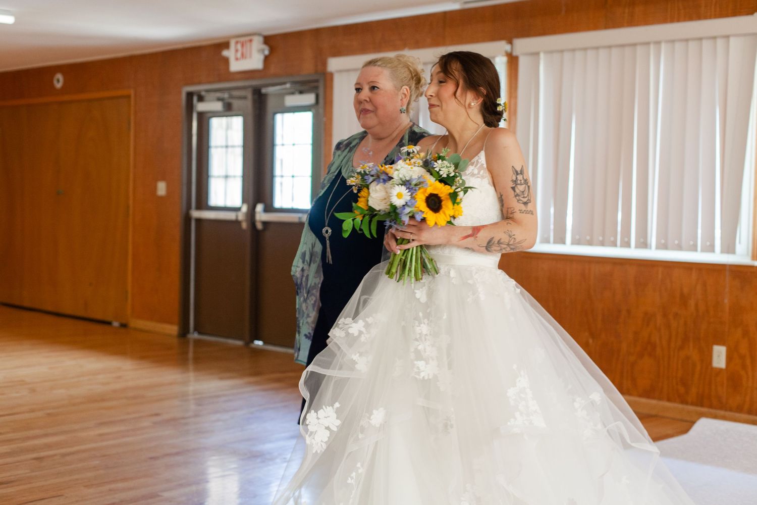 Wedding celebration in a rustic venue with wooden walls and elegant lighting fixtures.