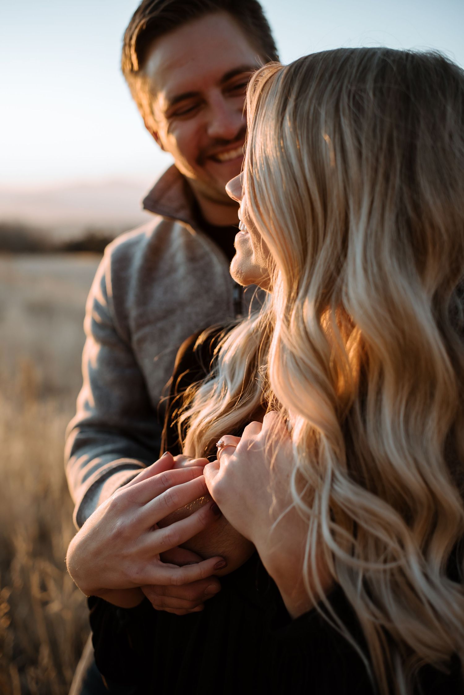 Close-up of couple sharing affectionate moments in golden field.