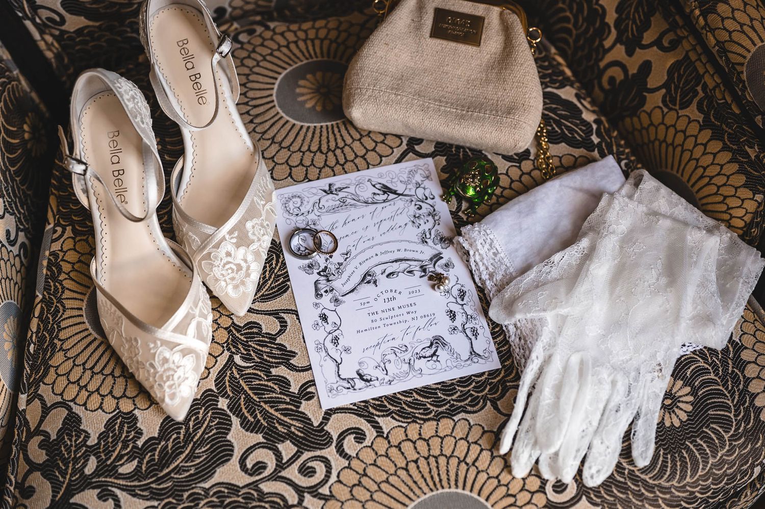 Wedding accessories including white gloves, shoes, and invitation cards on lace background.