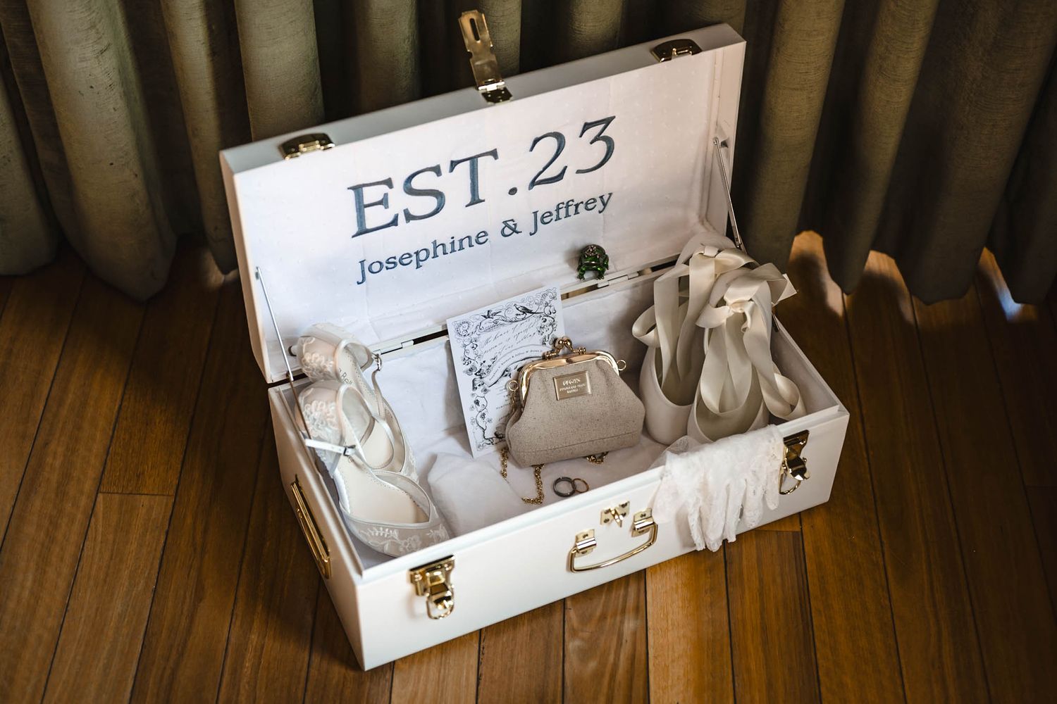 Wedding signage and decorative elements arranged on wooden flooring.