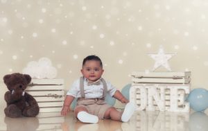 Baby milestone photo shoot setup with stars and blue accents against a light backdrop.
