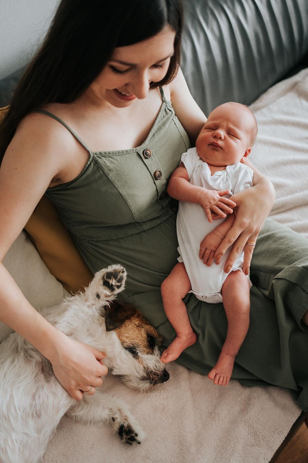 mama trzyma noworodka i głaszcze psa - fotograf rodzinny Kraków