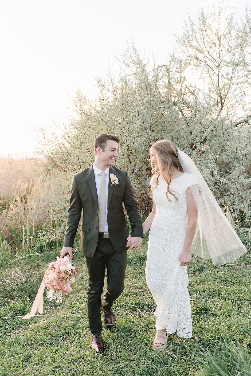 A springtime wedding photo shoot with white blossoming trees in the background.