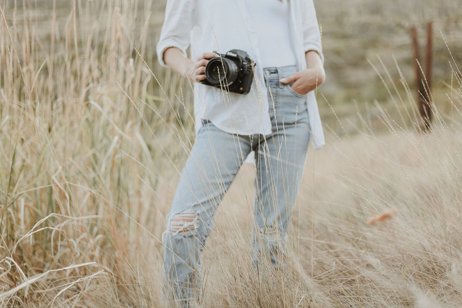 Okanagan wedding photographer picture. Photographer standing in a grass field holding a camera