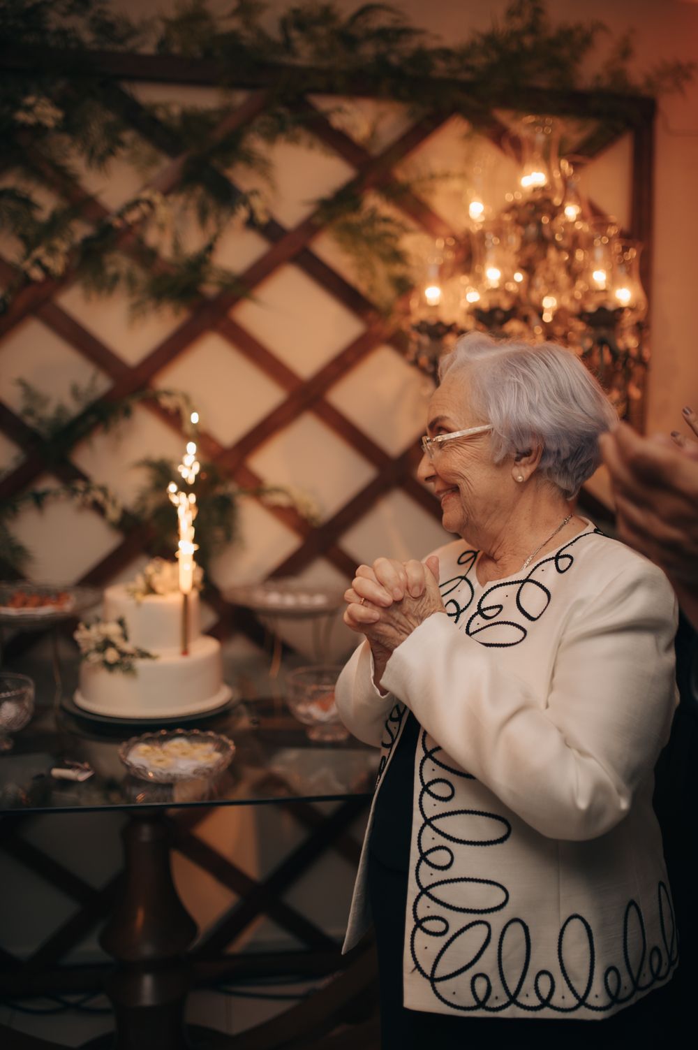 An elegant celebration scene with sparklers and decorative lattice backdrop during a special occasion.