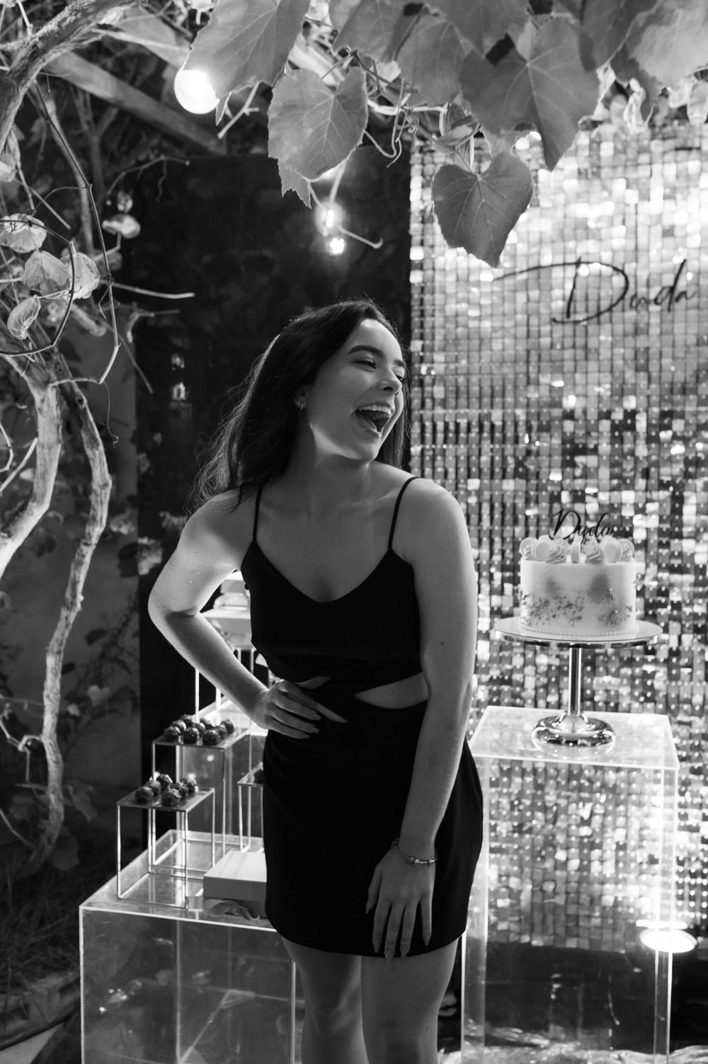 Black and white photo of celebration scene with sparkling backdrop and festive lighting.
