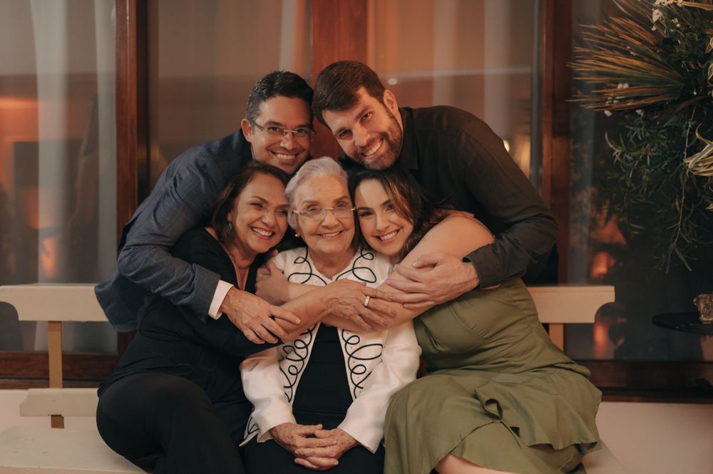 A joyful family moment captured in a warm, intimate indoor setting with everyone hugging close together.
