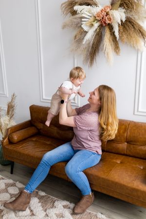 Playful moment on brown leather couch under dried floral wall decoration.
Janesville, WI
Brodhead, WI