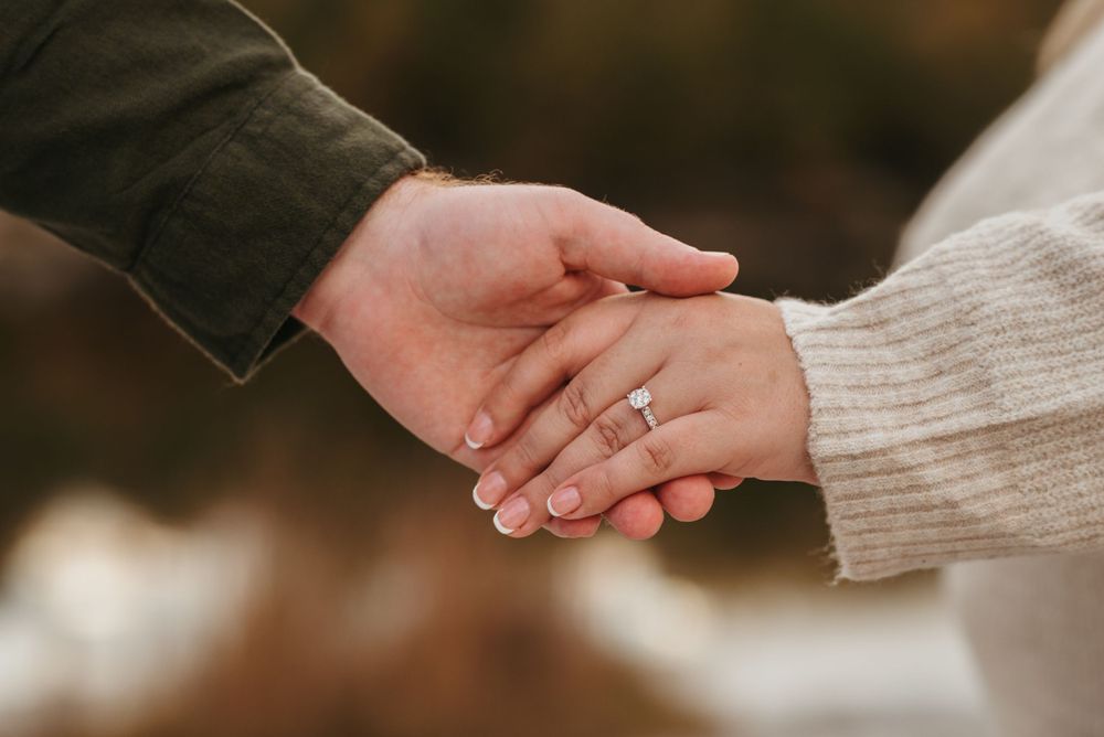 Close-up shot of hands tenderly holding hands in warm lighting.