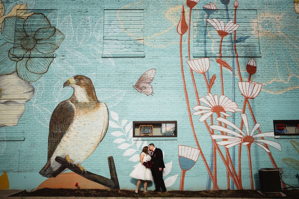 Artistic wall mural featuring bird and floral designs creates romantic backdrop.