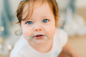 Close up of baby with bright blue eyes in winter themed photo setting.