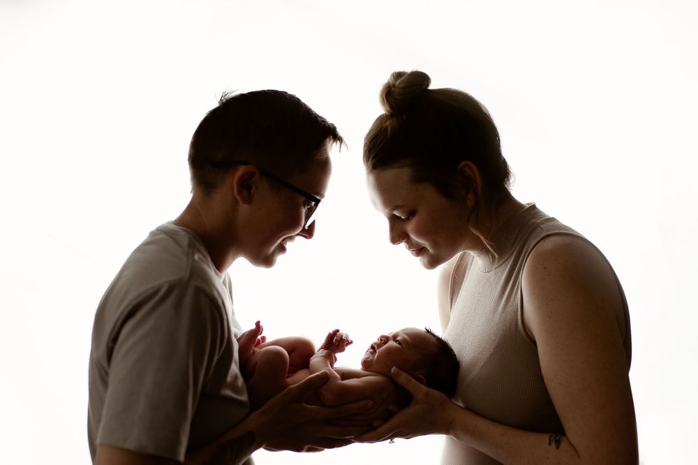 Backlit image of parents holding newborn -Pueblo, Colorado Newborn Photographer