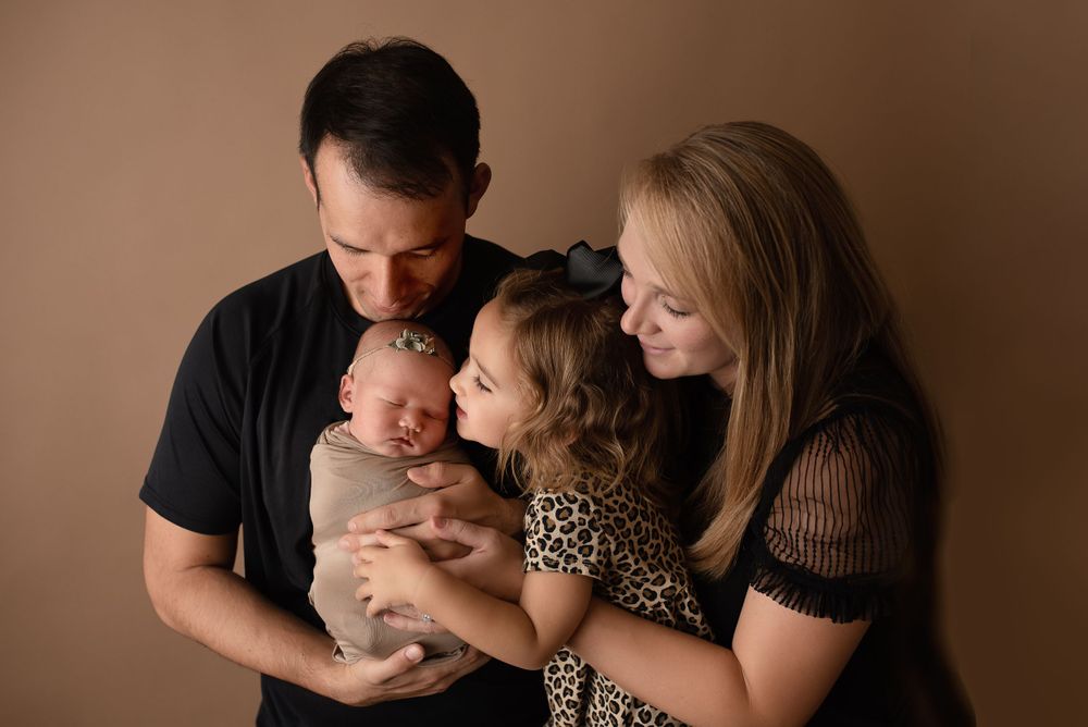family holding newborn and smiling -Pueblo, Colorado Newborn Photographer
