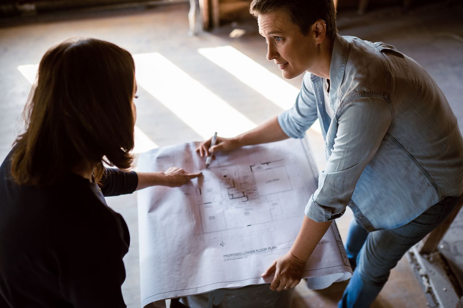designer and build contractor looking at plans with client during brand photo shoot