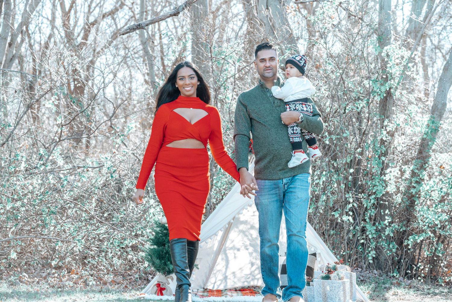 Couple walking on path with woman in red dress and winter scenery background.