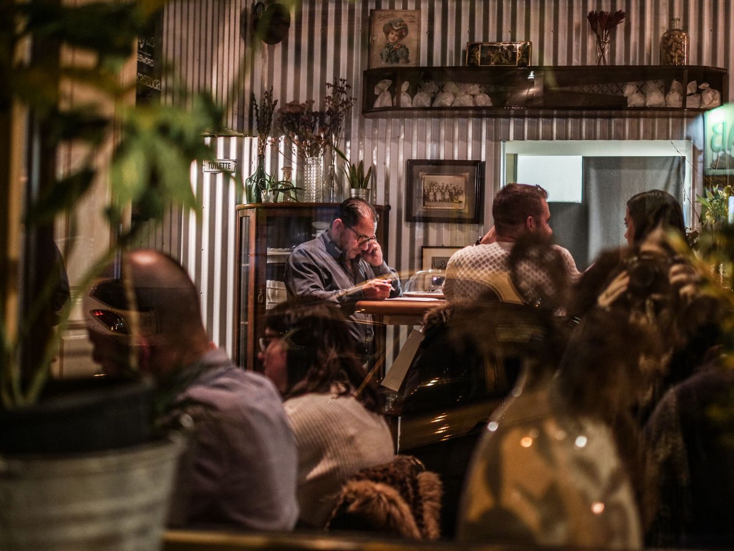 Restaurant owner sitting at bar making an important phone call.