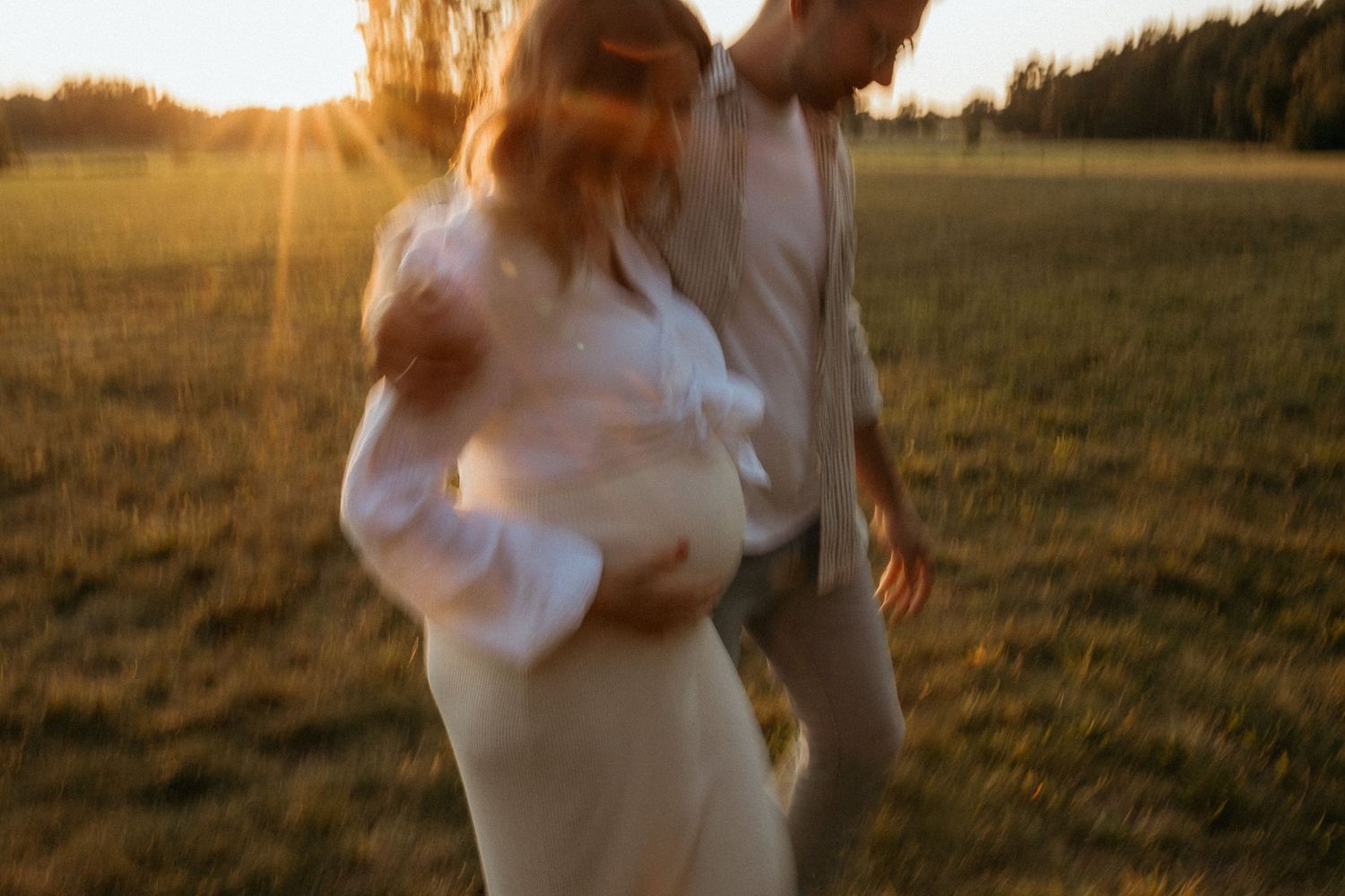 Golden hour sunset photo session in an open field with warm lighting.