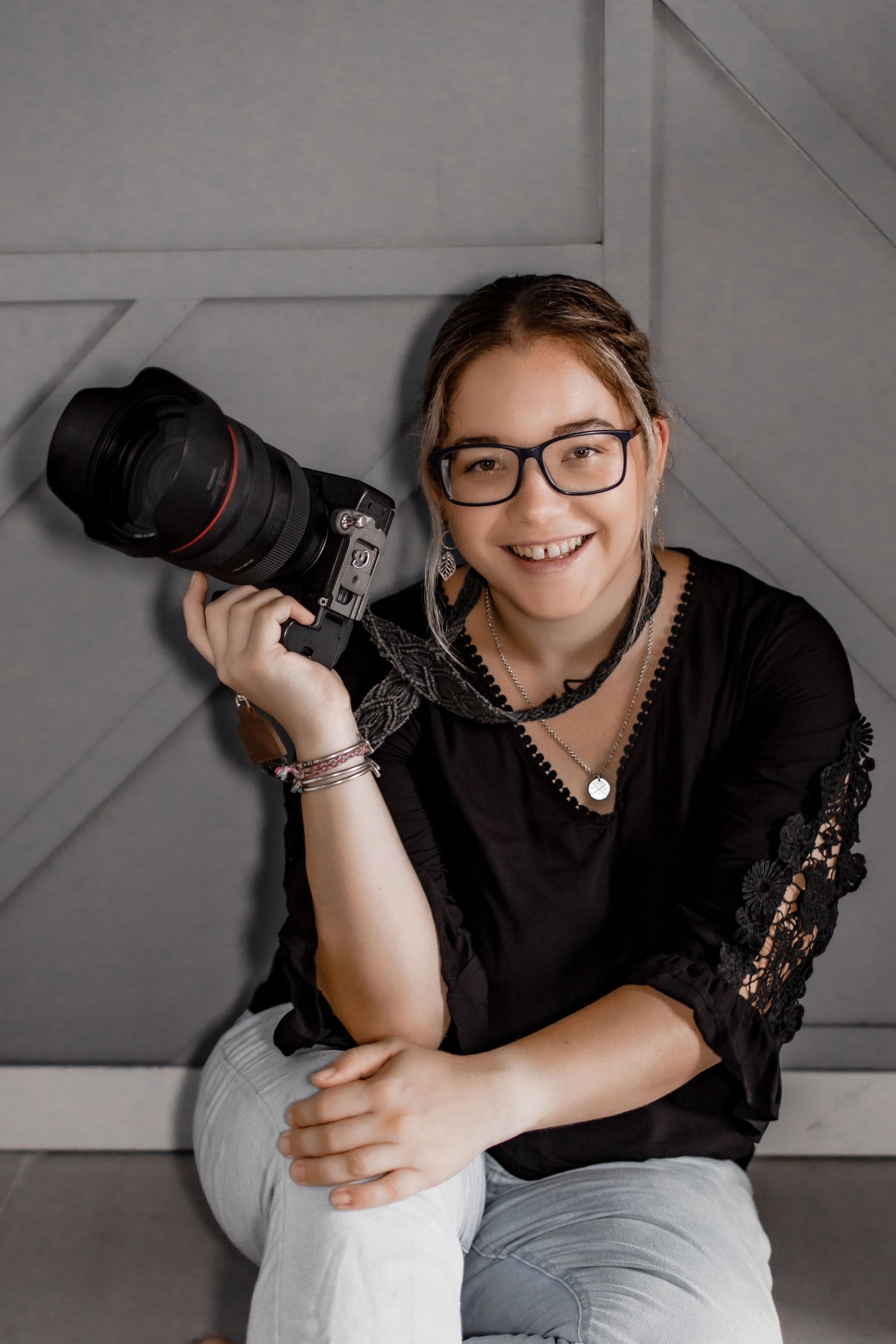 A photographer holding a professional camera with a telephoto lens.