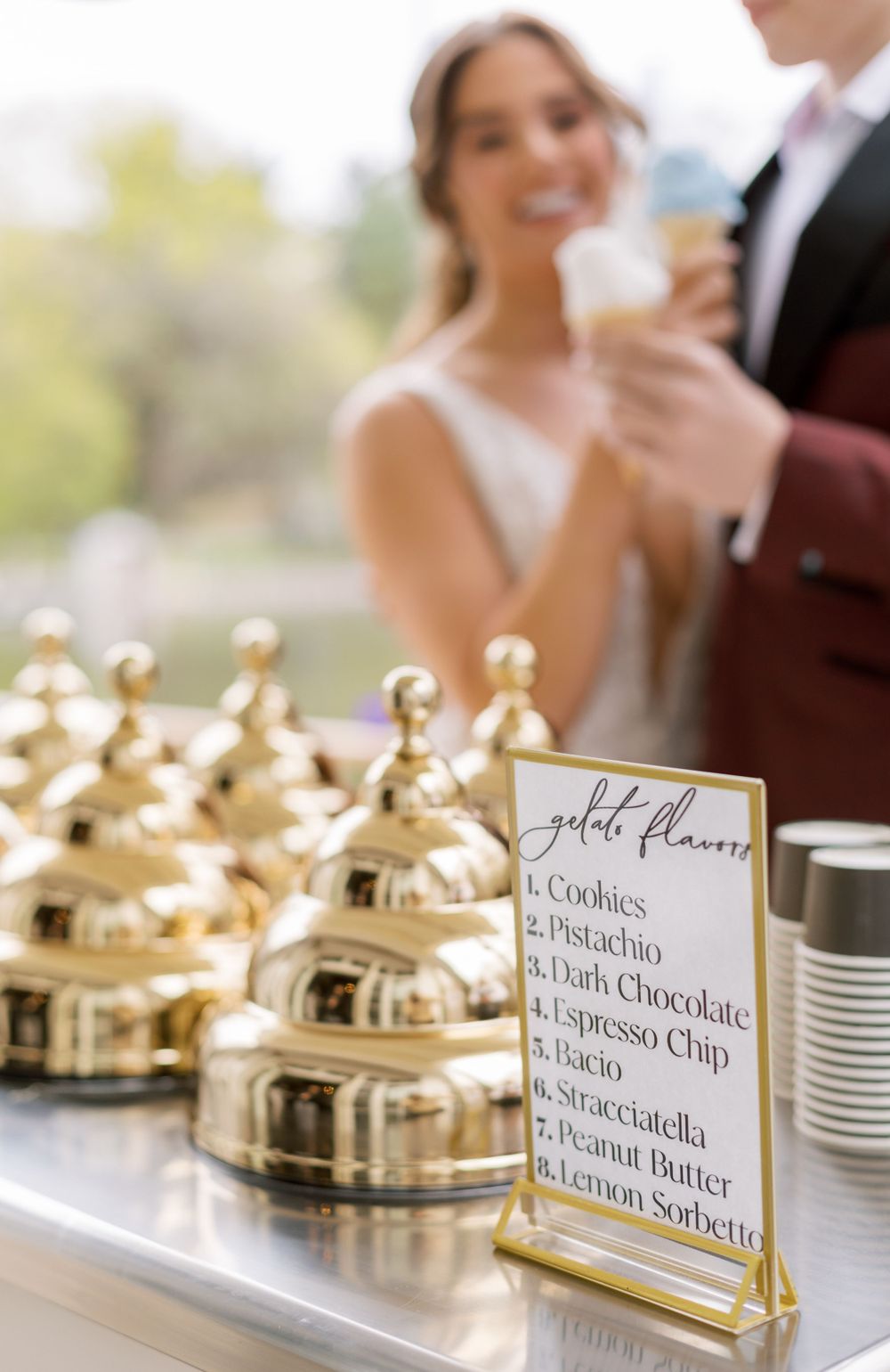 Wedding gelato cart with gold domed toppings and flavors menu on display.