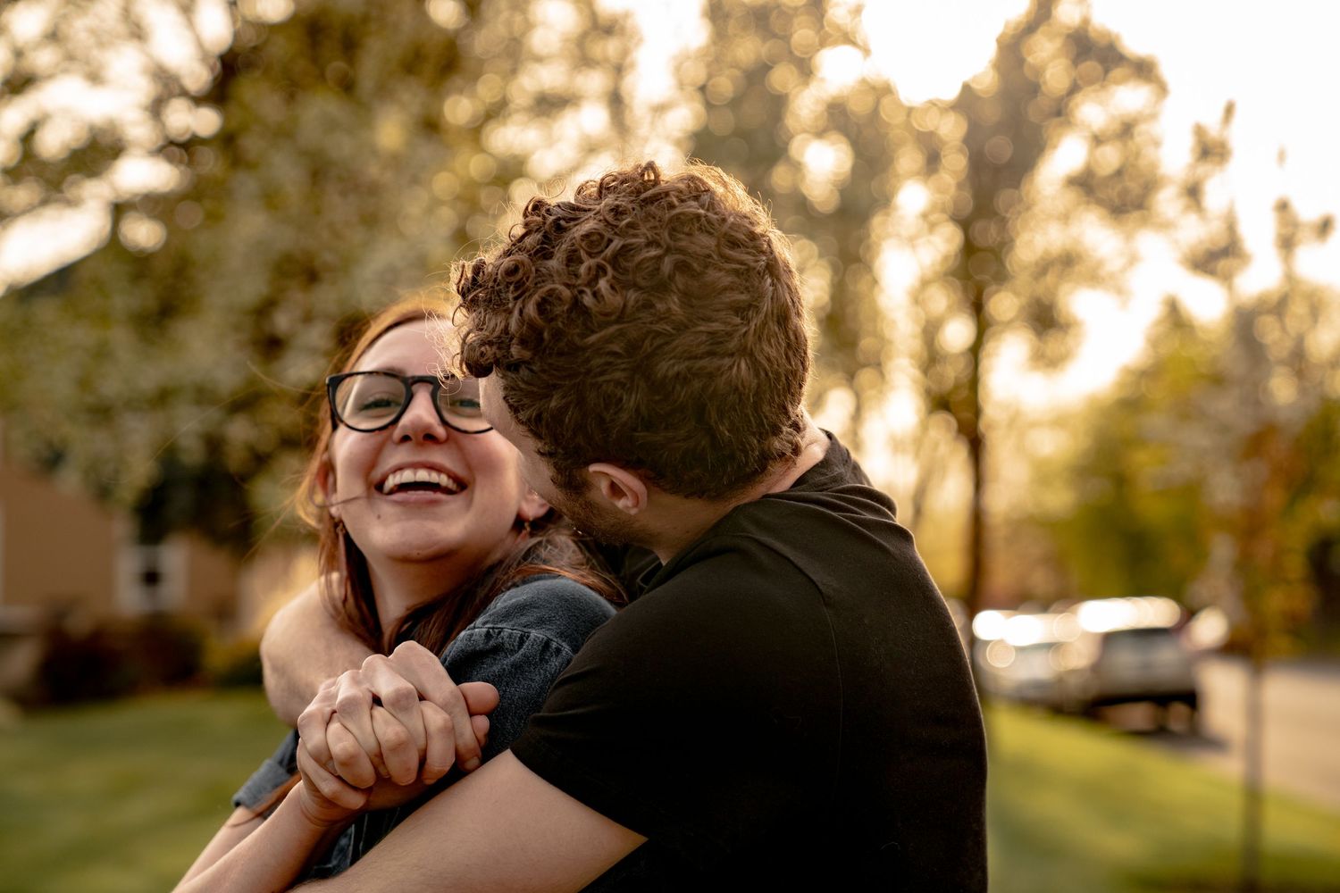 A joyful embrace shared between two people during golden hour outdoors.