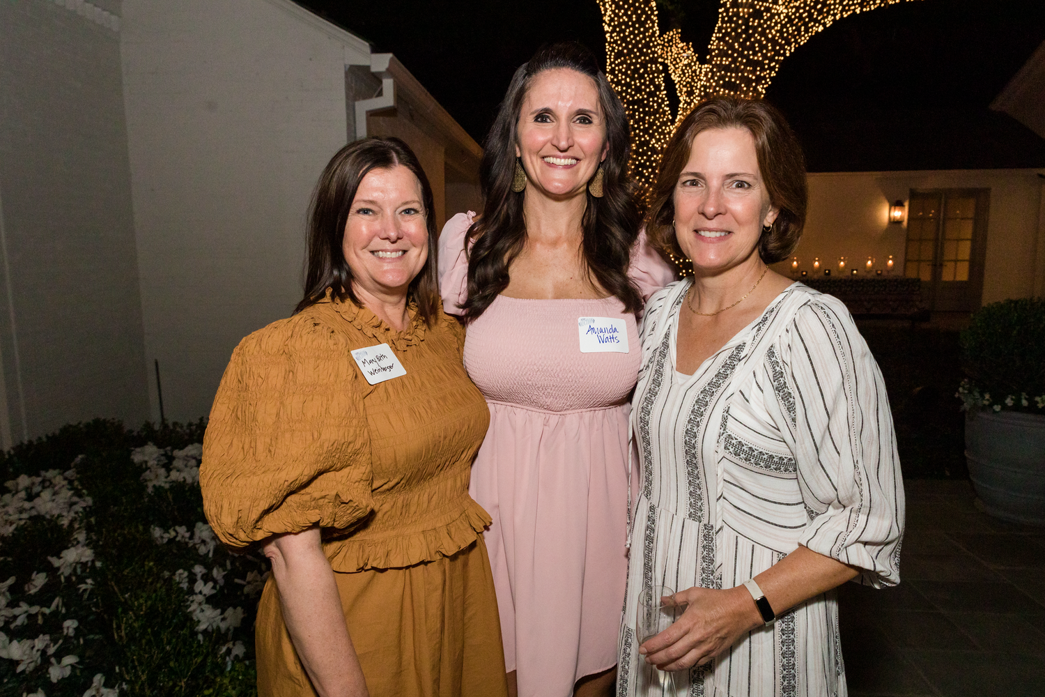Small groups of attendees mingling and posing together at a social gathering.