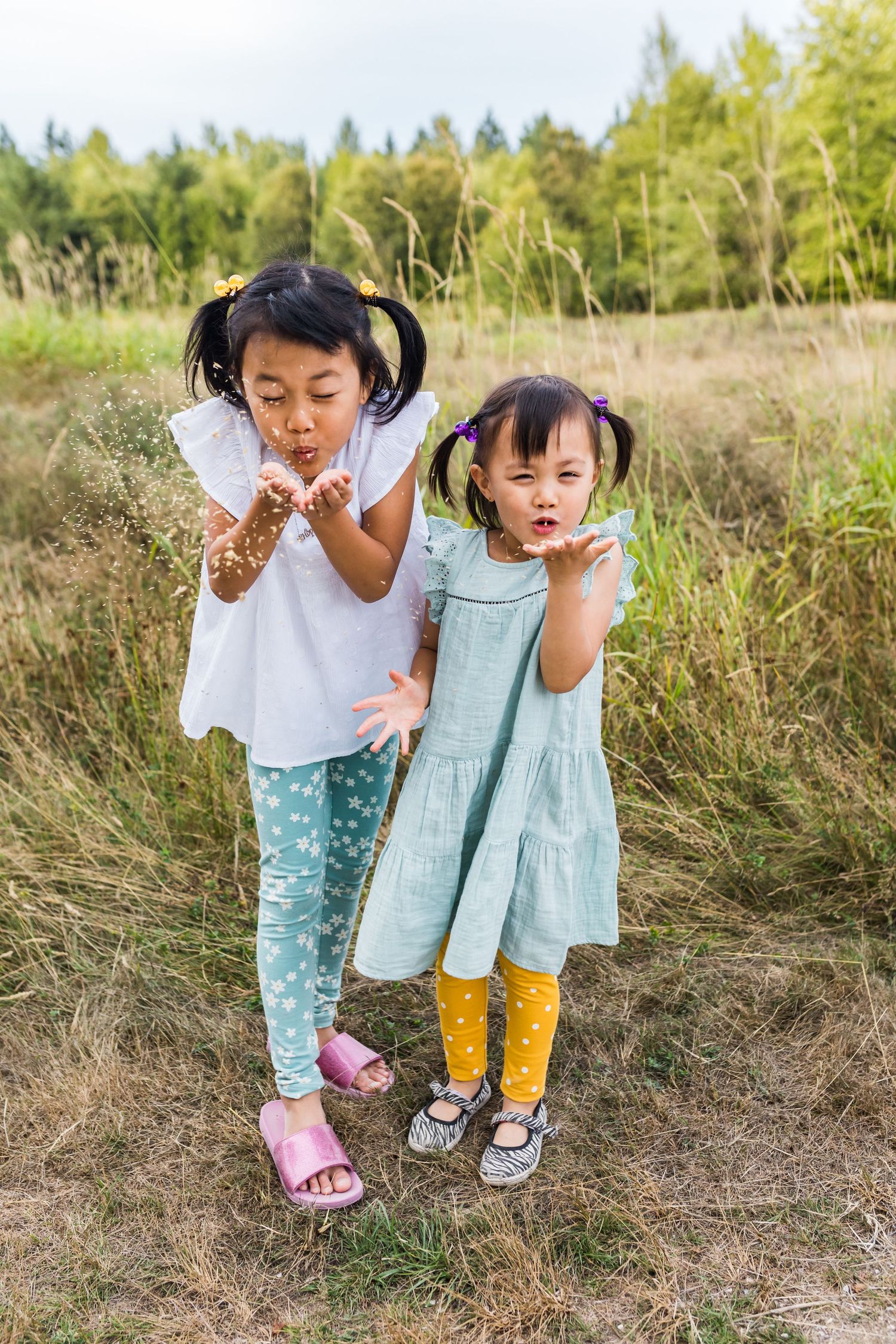Candid moment of sisters blowing wheat in Surrey BC