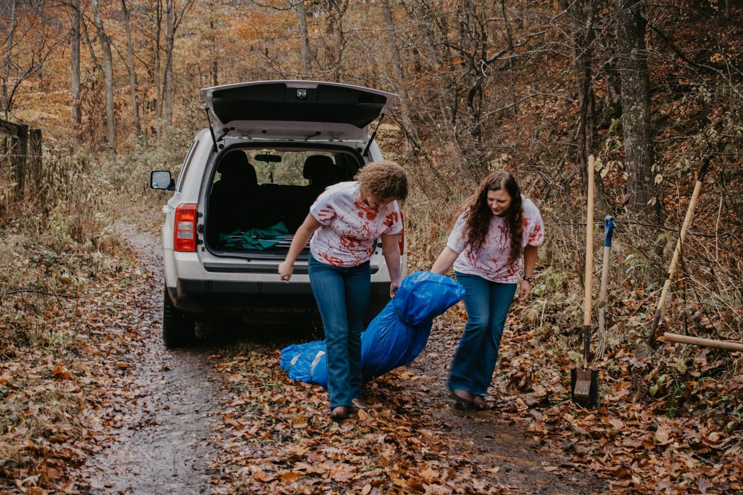 two females dragging a fake body during best friend session