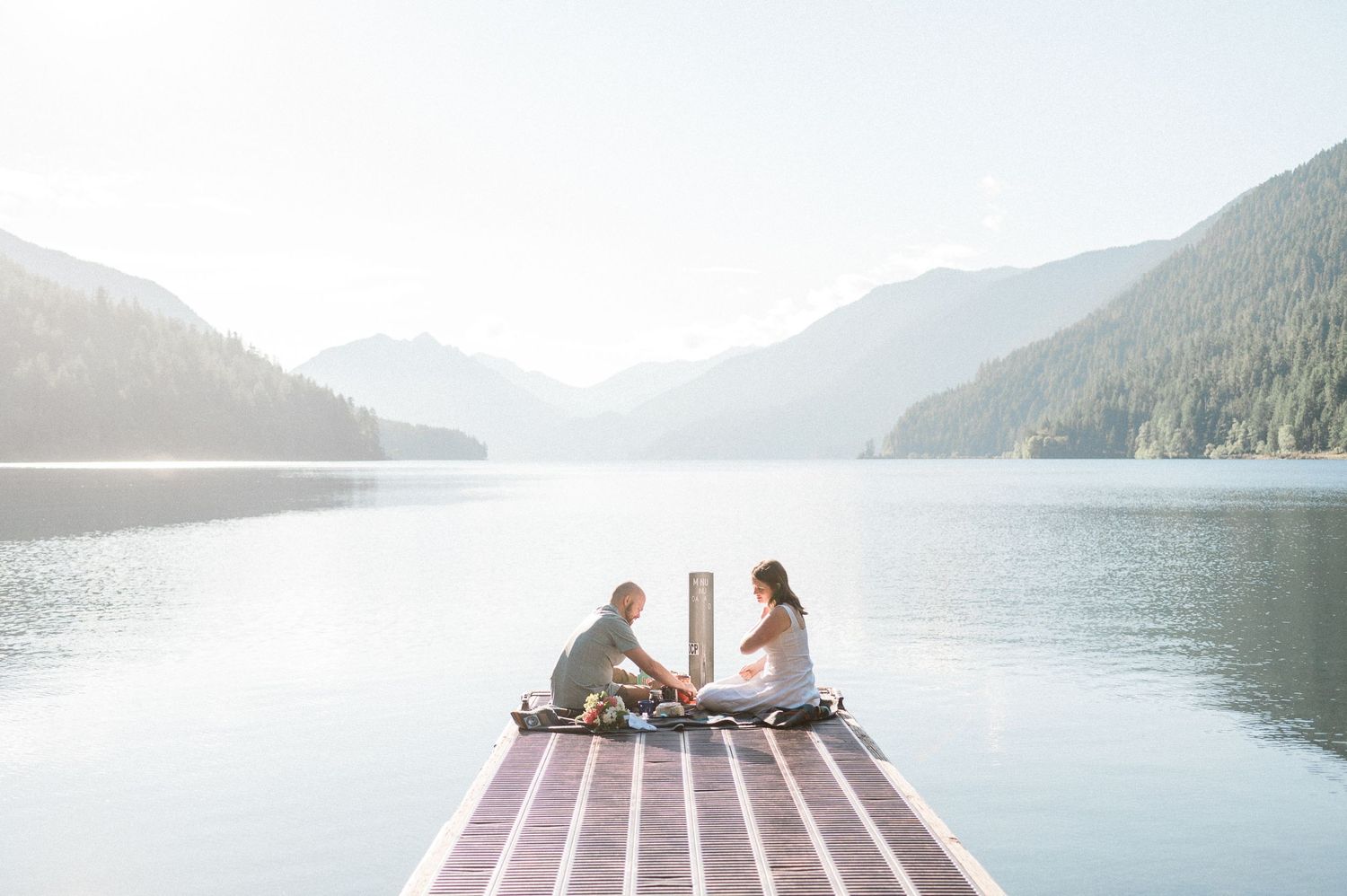 Bride and groom have breakfast on dock during their Lake Crescent Elopement. Photo by Washington elopement photographer.