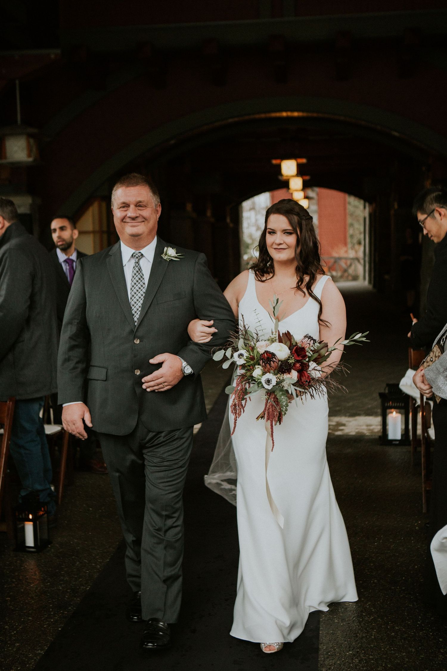 Wedding procession walking through an arched doorway during ceremony.