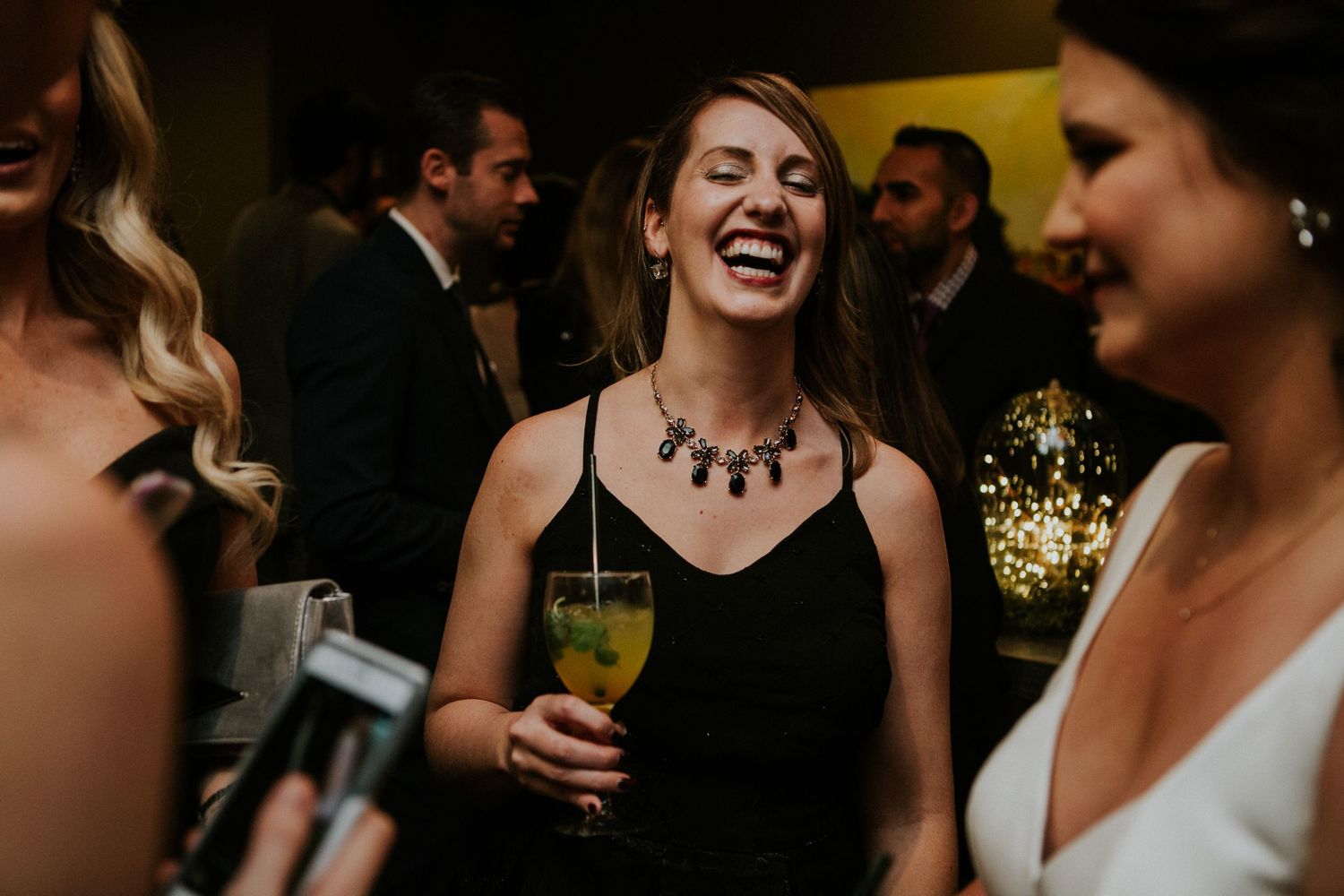 Party guests enjoying drinks and conversation at an elegant evening wedding reception.