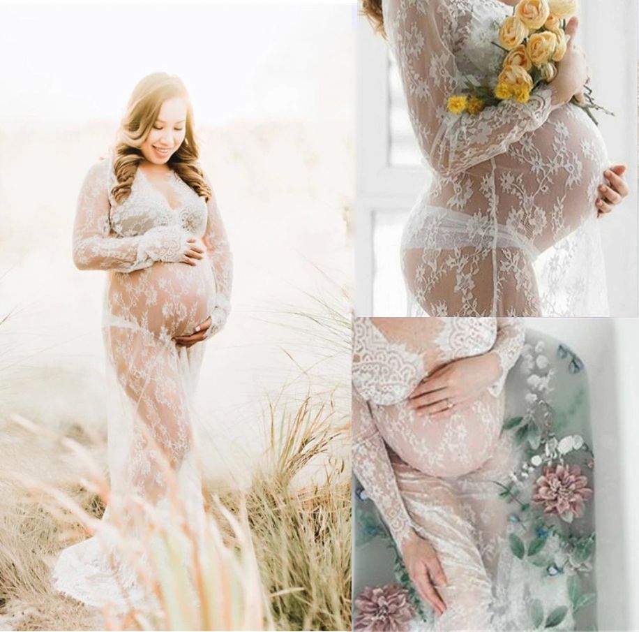 Pregnant woman wearing an elegant sheer lace maternity gown holding a bouquet of flowers.