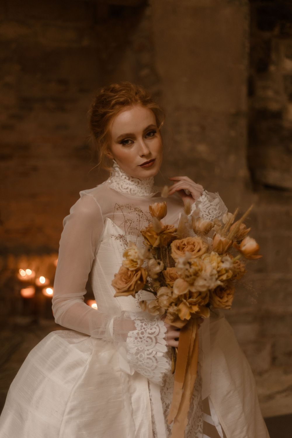 Romantic bridal portrait featuring a high-neck lace gown and peach-toned bouquet.