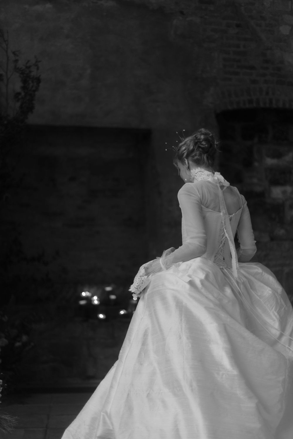 Black and white photograph of bridal gown silhouette with detailed back design in stone interior.