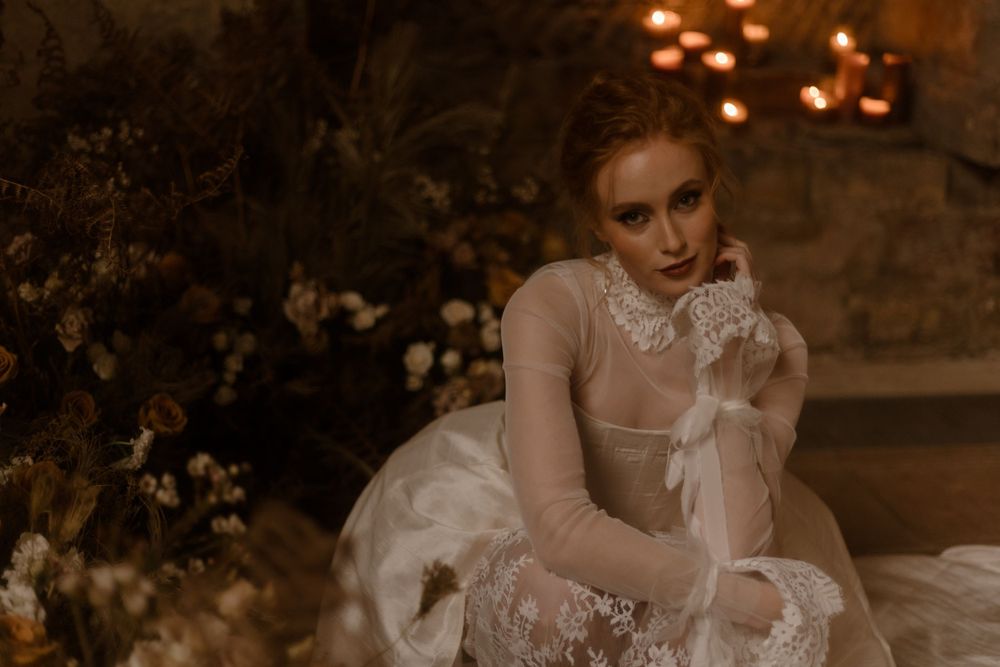 Dreamy bridal portrait in a sheer lace gown with warm candlelight ambiance.