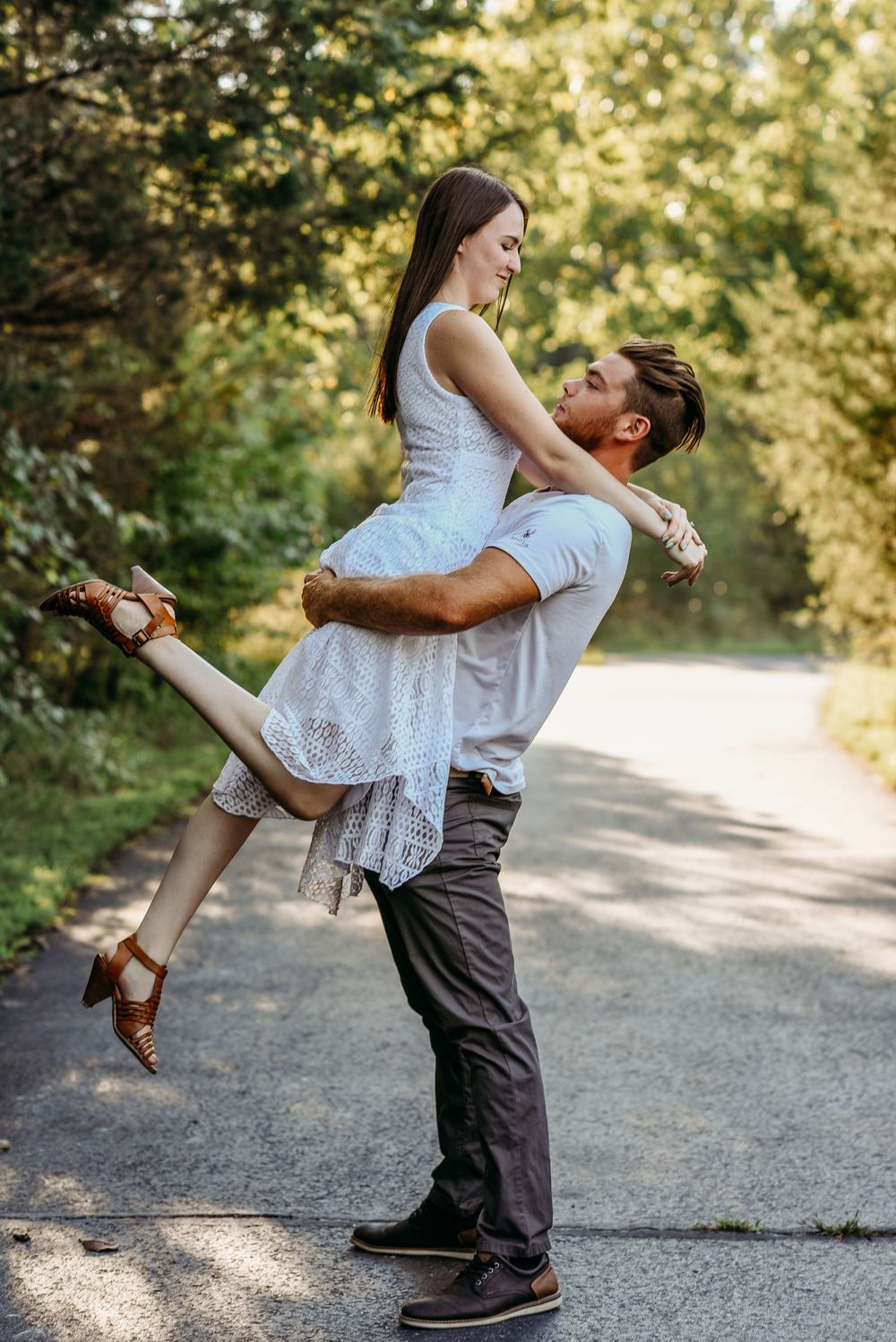 A playful outdoor photoshoot sequence showing a couple spinning and embracing on a path.