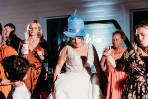 Wedding reception dance floor with guests celebrating in coral and floral dresses. Middle TN wedding photographer
