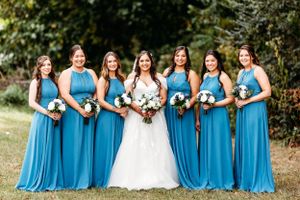 Bridesmaids in matching turquoise blue dresses pose with the bride outdoors.Middle TN wedding photographer