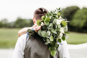 Wedding bouquet details featuring fresh greenery and white flowers against natural outdoor backdrop.Middle TN wedding photographer
