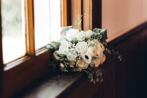Elegant white and blush floral wedding bouquet arrangements on wooden surface. Middle TN wedding photographer