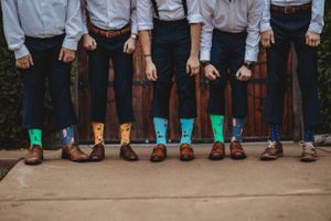 Groomsmen showing off colorful patterned socks in a fun lineup pose.Middle TN wedding photographer