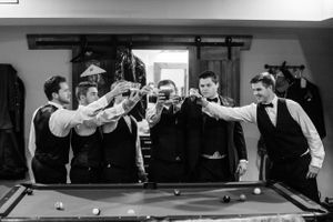 Wedding party having fun playing pool in formal attire at reception venue.  Middle TN wedding photographer