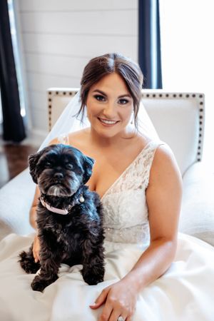 A small black dog sits with bride wearing a white wedding dress.  Middle TN wedding photographer