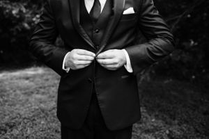 Groomsmen in black tuxedos and bow ties standing together outdoors.Middle TN wedding photographer