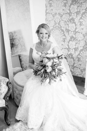 Bridal portraits against floral wallpaper showing white lace wedding gown and bouquet. Middle TN wedding photographer