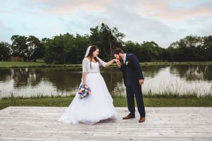 Wedding couple poses on wooden dock overlooking serene lake during sunset. Middle TN wedding photographer