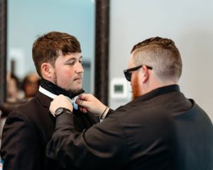 Groomsman fixing groom's bow tie prior to wedding.  Middle TN wedding photographer